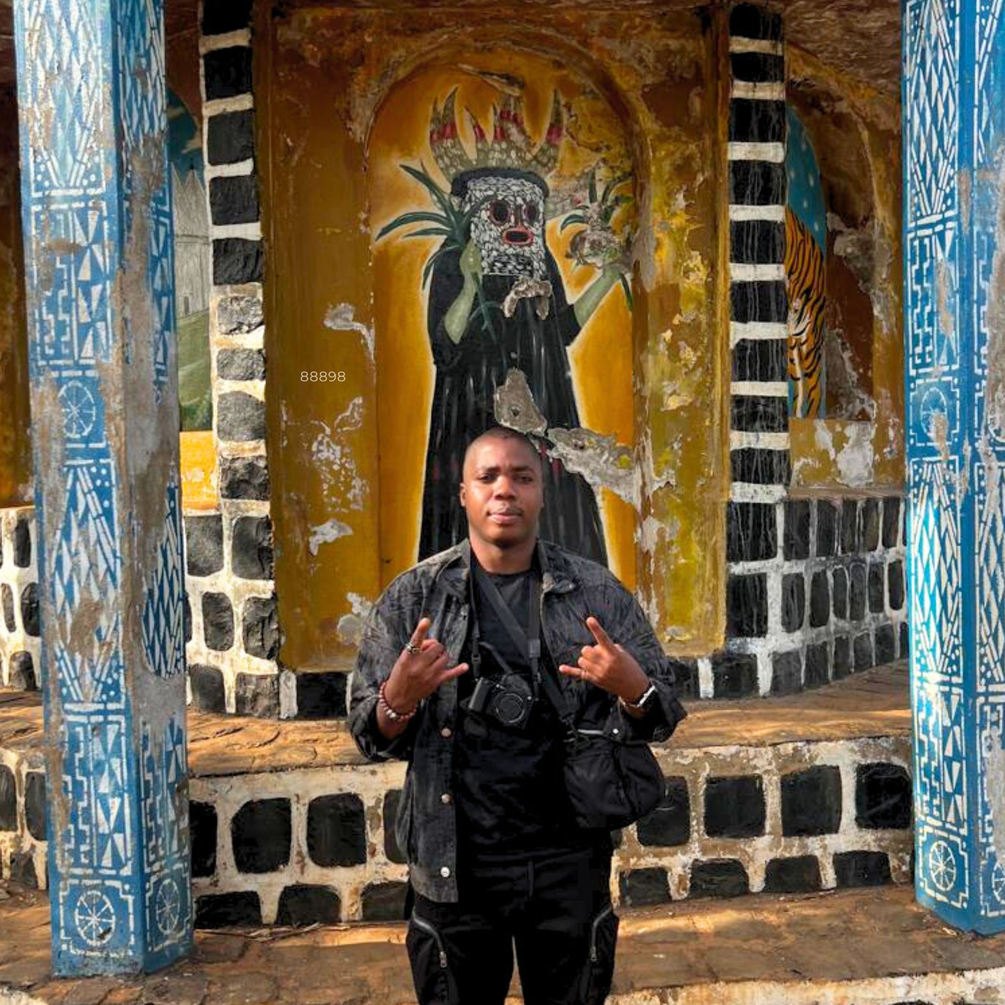 Man standing confidently before Bamileke traditional art in Bafoussam, reflecting what makes a man attractive through rooted identity